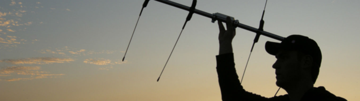 man using a hand held antenna to do radio telemetry wildlife tracking.